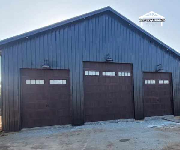 Exterior view of a contemporary metal-sided pole barn home featuring white trim and a spacious covered deck.